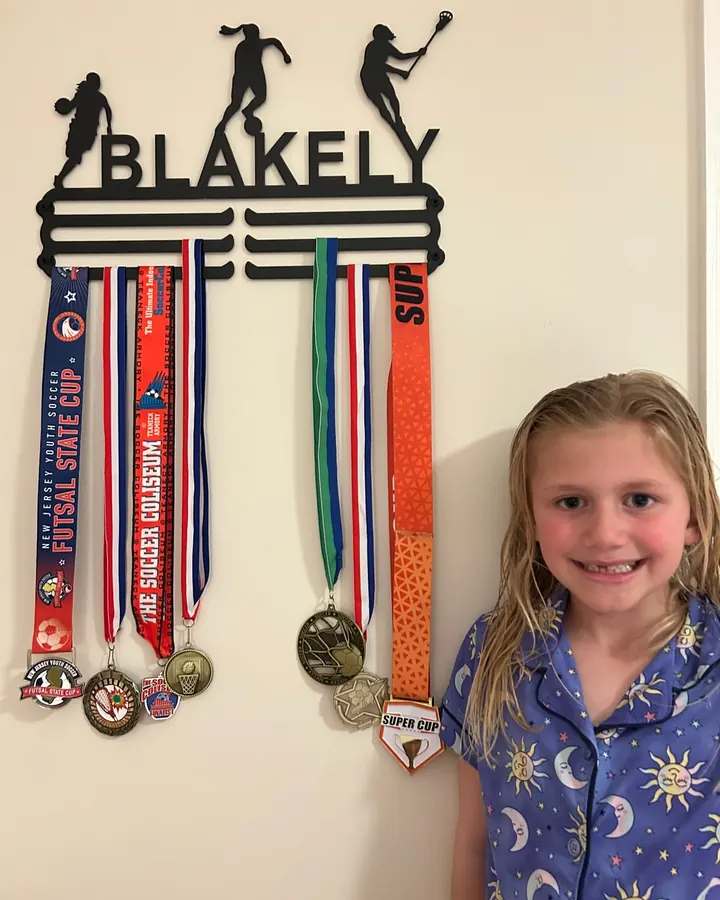 Blakely next to her personalized medal hanger and medals