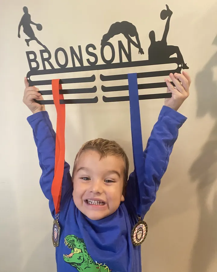 Bronson holding his personalized medal hanger over his head